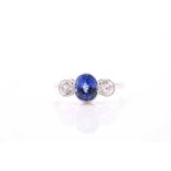 A platinum, diamond, and sapphire ring, collet-set with a mixed oval-cut sapphire of approximately