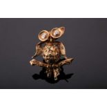 An 18ct yellow gold, diamond, and emerald novelty brooch in the form of an owl, the wide eyes set