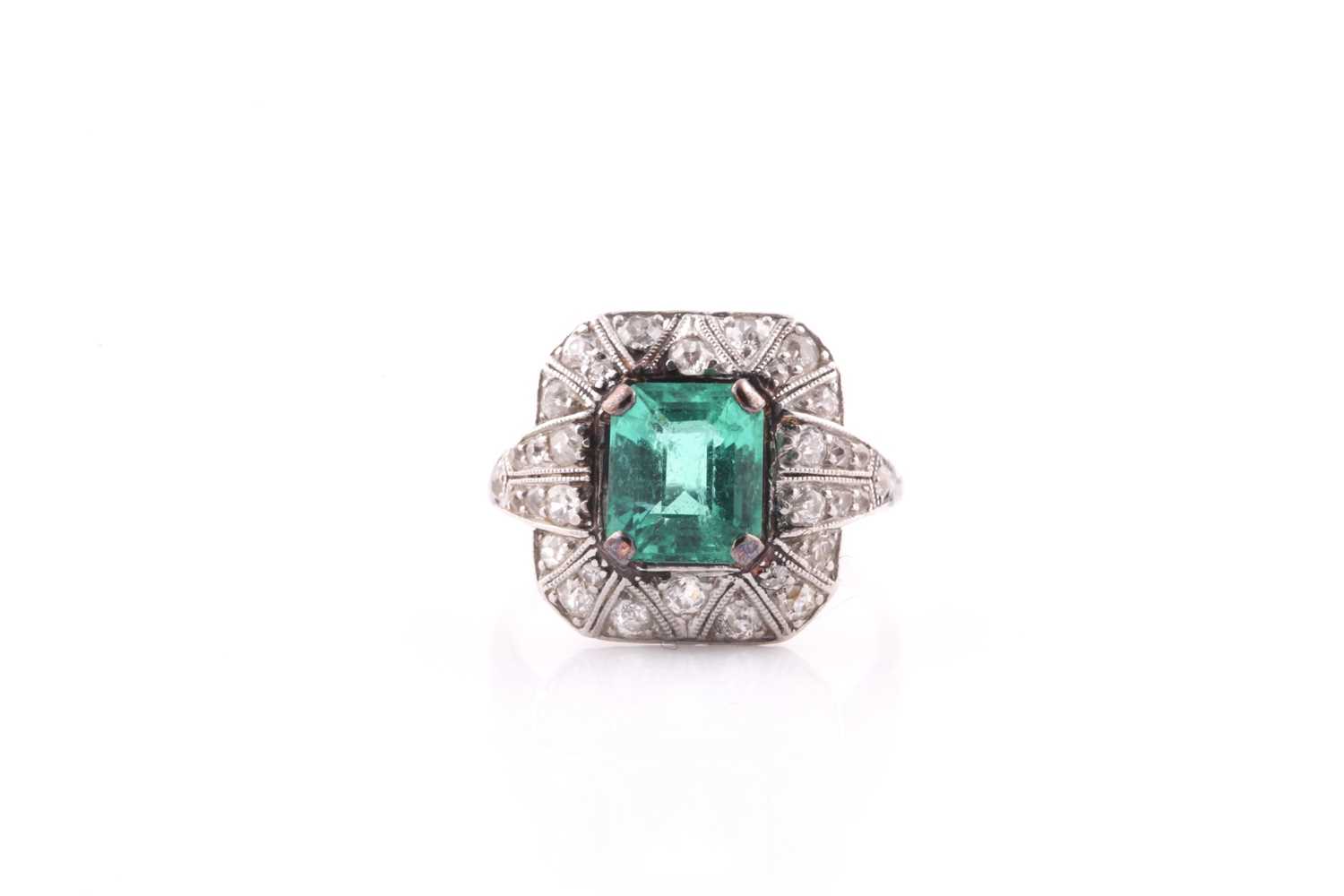 An emerald and diamond dress ring, set with an emerald-cut emerald, measuring approximately 7.8 x