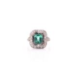 An emerald and diamond dress ring, set with an emerald-cut emerald, measuring approximately 7.8 x