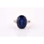 A sapphire and diamond three stone ring, the oval cut sapphire measuring approximately 14 x 10.5 x