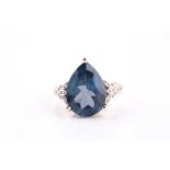 A 9ct yellow gold and blue topaz dress ring, set with a pear-cut deep blue topaz, measuring