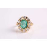 An 18ct yellow gold, emerald and diamond cluster ring, oval emerald measuring 9.6 x 7.5 x 4mm