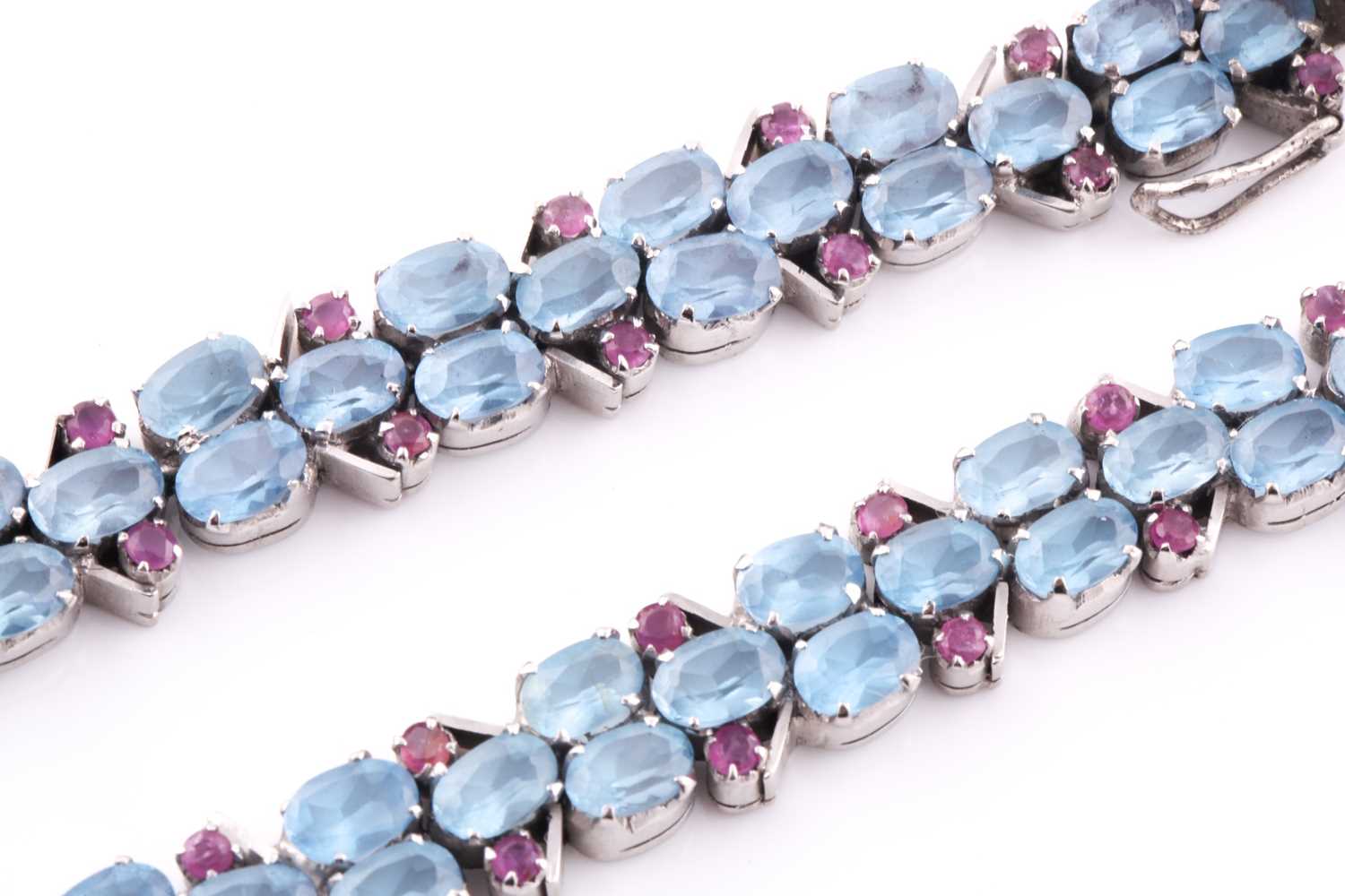 A white metal, blue topaz and ruby bracelet, set with mixed oval-cut blue stones and smaller round- - Bild 3 aus 3