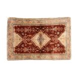 An antique Turkish rust-red ground silk mat with a central lozenge with ivory floral borders. 65