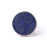 A probably Persian white metal dress ring set with a circular lapis lazuli panel engraved with
