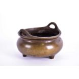 A Chinese bronze censer, Qing, 19th century, with loop handles above a slightly compressed body on