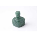 An Eastern carved variegated green hardstone scent bottle of trapezoidal section with pommel