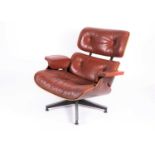 A Charles Eames for Herman Miller lounge armchair, with tan buttoned hide and laminated Zebrano body