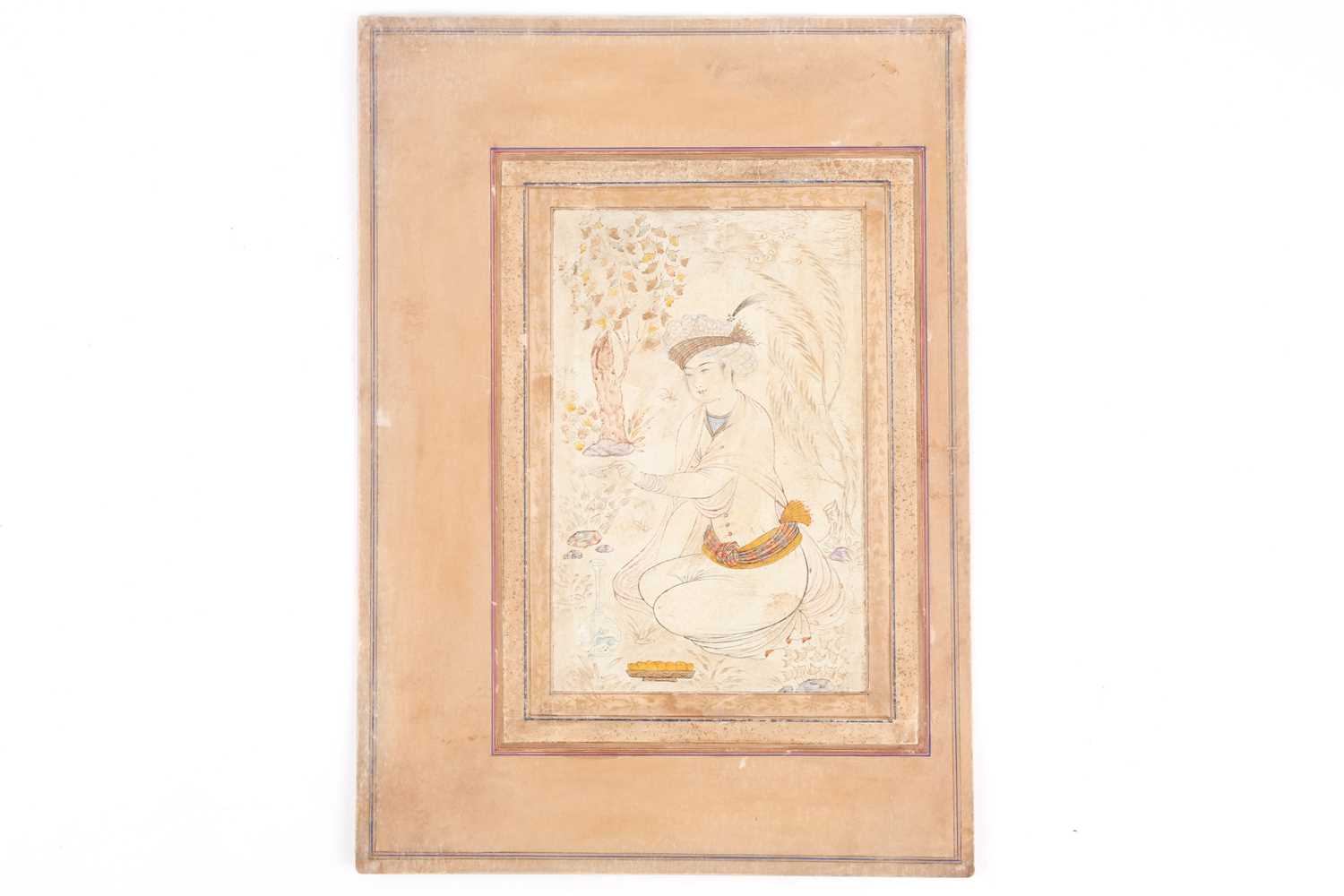 Mughal school, 19th century, a nim qalam pen and coloured ink Prince in a garden, kneeling whilst