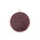 An Indo Persian red hardstone pendant in silver metal mount, of rounded octagonal shape, engraved