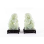 A pair of Chinese carved pale green Jadeite figures of "Dogs of Fo", 20th century. On mock cloth