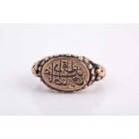 A Persian gold coloured metal gentleman's ring, in the early Qajar style, engraved with
