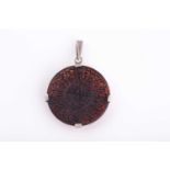 An Indo Persian dark red gem pendant, engraved with calligraphy, in white metal mount.
