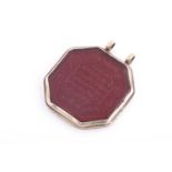 An Indo Persian red hardstone octagonal pendant in silver metal mount,