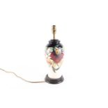 A Moorcroft pottery 'Anna Lily' pattern table lamp, of baluster form with wooden base, 38.5 cm