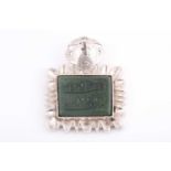 An Indo Persian white metal and jade pendant, the jaded engraved with two lines of calligraphy,