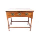 An early 18th-century oak single drawer lowboy, with thumb, moulded planked top over a single frieze