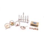 A small group of collectable items, comprising: a silver toast rack, a caddy spoon, a brass matchbox