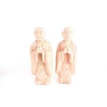 A pair of Chinese carved and earth pigment painted wooden figures of Buddhist monks one with hands