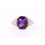 An amethyst and diamond ring, the faceted cushion shape amethyst with six round brilliant cut