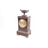 An early 19th century bronzed brass clock of classical form with twin handled urn finial, laurel