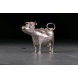 An 18th century white metal cow creamer in the manner of John Schuppe. Bearing cancelled hallmarks