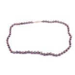 A single-strand black cultured pearl and diamond necklace The slightly graduated row of 6.7-9.4mm
