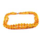 A double-strand amber necklace, each graduating row of 10.2 mm-23.4 mm amber beads, to an S hook,