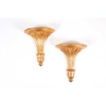 A pair of giltwood wall brackets of classical style, of volute fanned form with demi-lune plinths