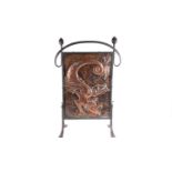 An Arts & Crafts style fire screen, with a hammered copper panel depicting a dragon, in an iron