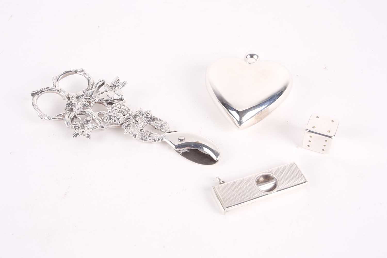 A group of small silver items, comprising a heart-shaped scent bottle, 7.2 cm high, a dice and a