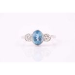 An aquamarine and diamond three stone ring, the 8 x 6mm oval aquamarine with a round brilliant cut