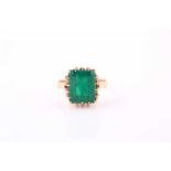 Emerald single stone ring, the rectangular step cut stone claw set to a yellow precious metal