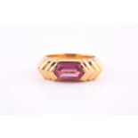 A pink sapphire ring by Bvlgari The fancy-cut pink sapphire to reeded shoulders, to a yellow metal