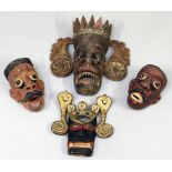 Vier div. Masken. Holz, geschnitzt und farbig gefasst. Altersspuren und kleinere Fehls