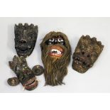 Vier div. Masken. Holz, geschnitzt und farbig gefasst. Einmal mit Haaren aus Pflanzenf