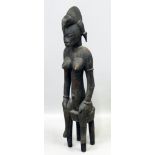 Sitzende Mutterfigur, Senufo. Dunkel patiniertes Holz, geschnitzt. Kopfputz mit Vogelk