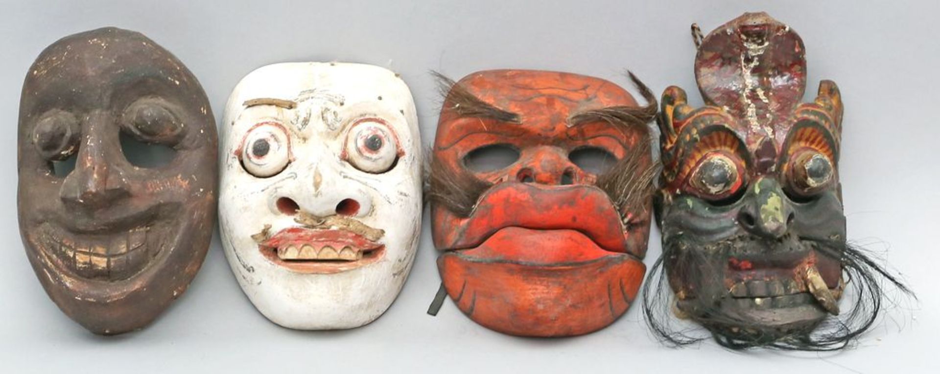 4 div. Masken. Holz, geschnitzt und überwiegend farbig gefasst. Altersspuren bzw. 1x