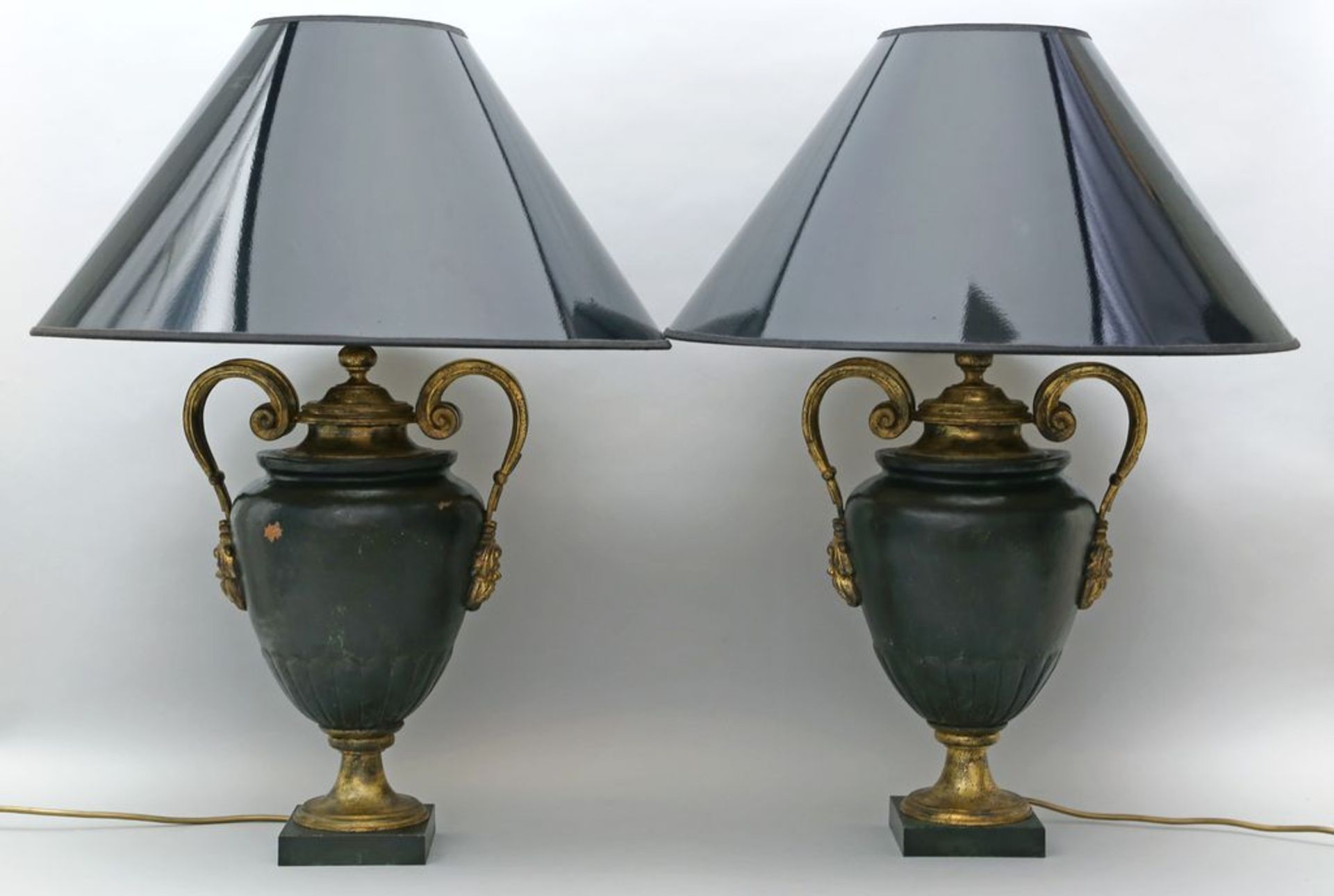 Paar Tischleuchten, je einflammig. Dunkelgrün gefasster Metallkorpus in Form einer Amphora mit vergo