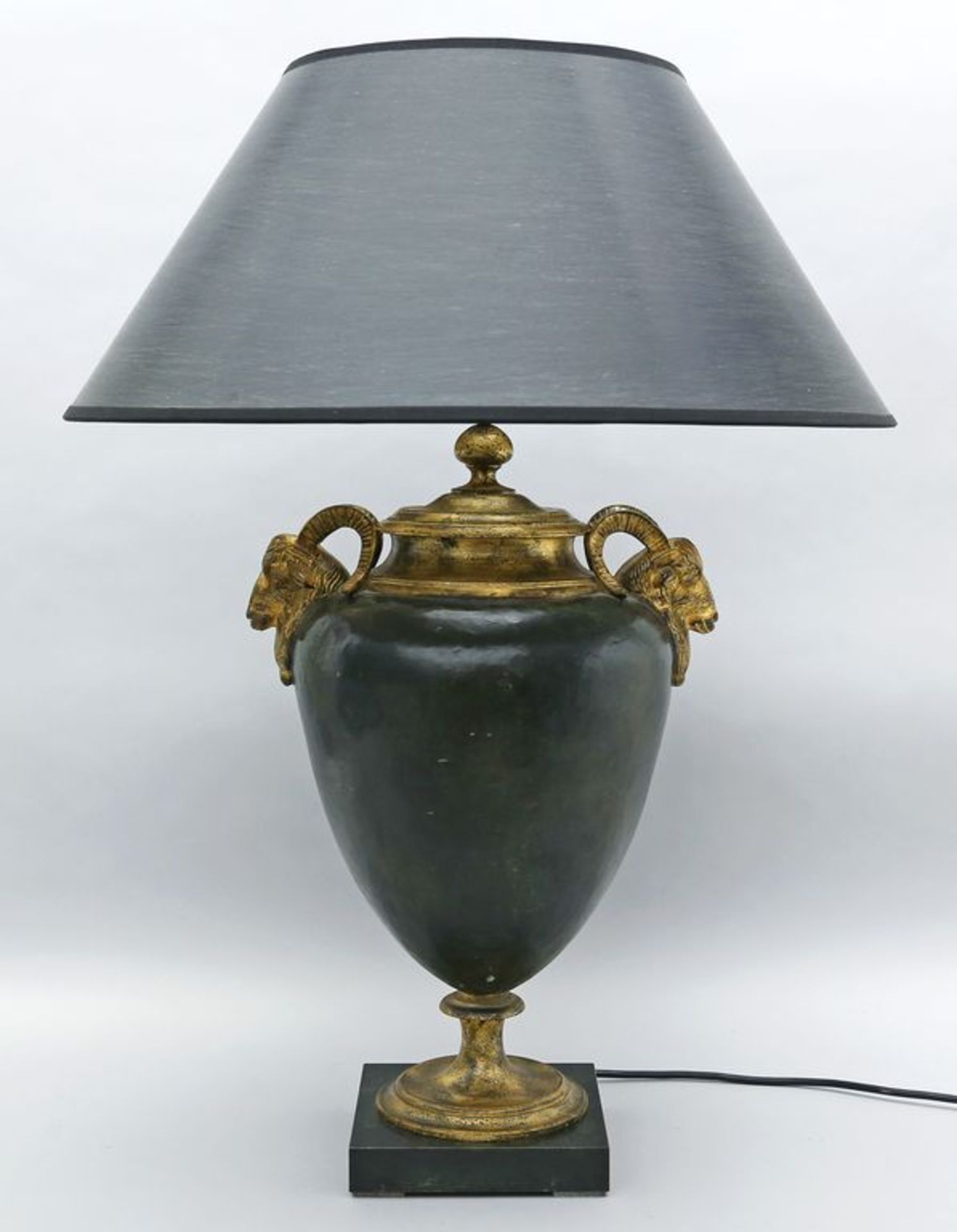 Tischleuchte, einflammig. Schwarz gefasster Metallkorpus in Form einer Amphora mit Paar vergoldeten,
