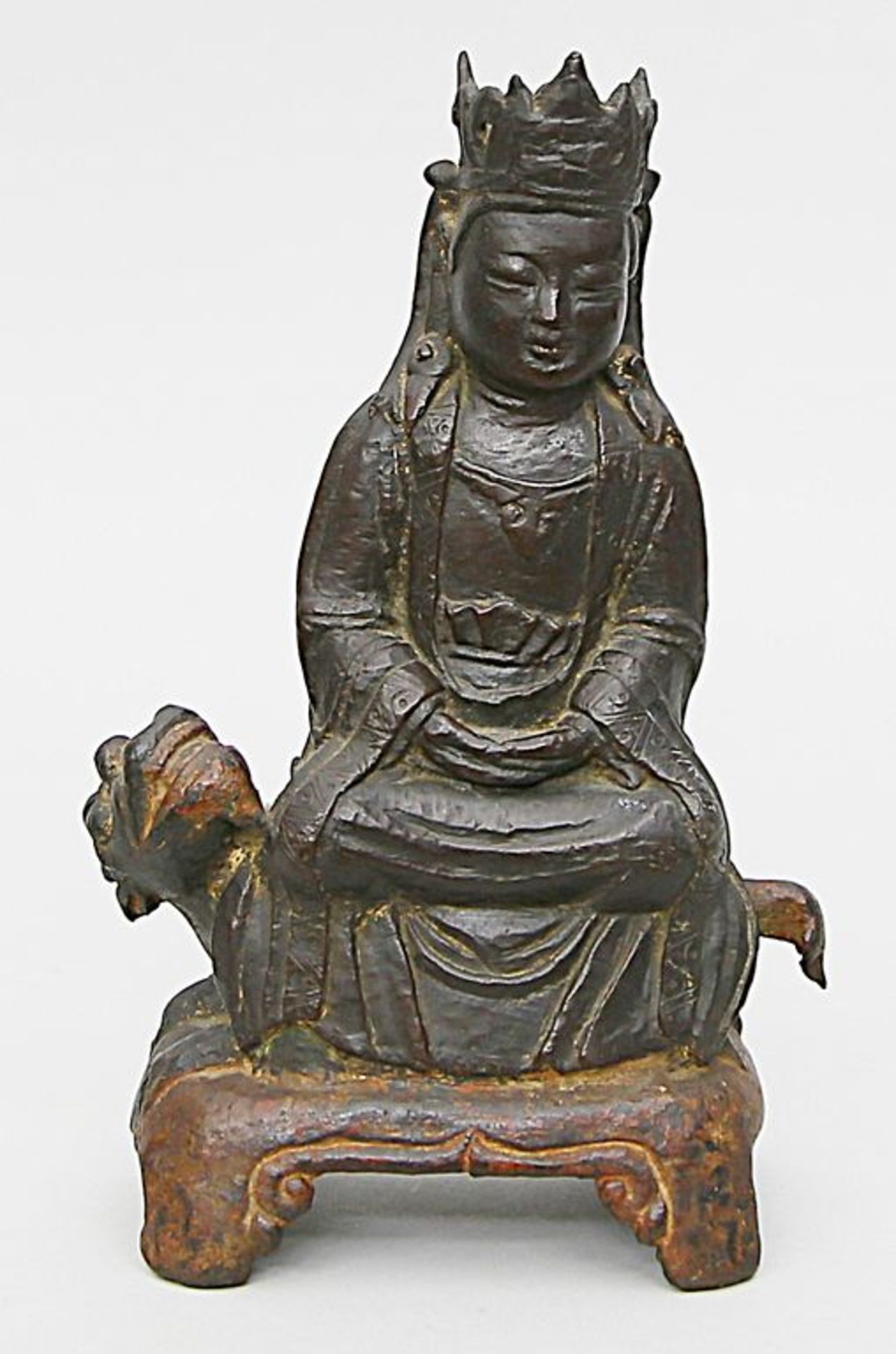 Guanyin, auf Qilin sitzend. Bronze mit Resten alter Patina. Einfacher Guss. China, wohl Ming-