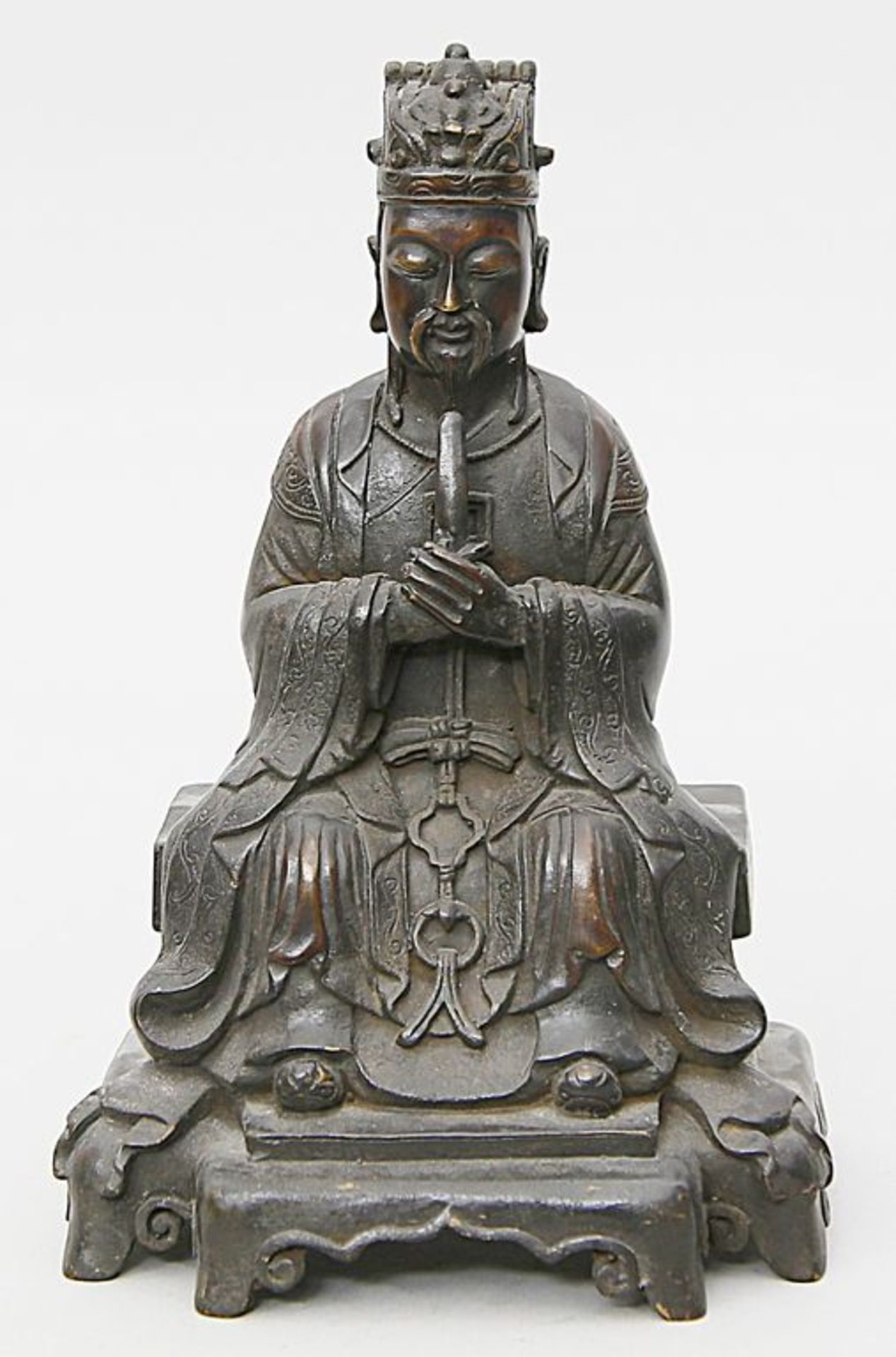 Ming-Skulptur eines Daoisten. Bronze mit schwarz-brauner Patina. Auf einem Thron mit Teppich sitzend