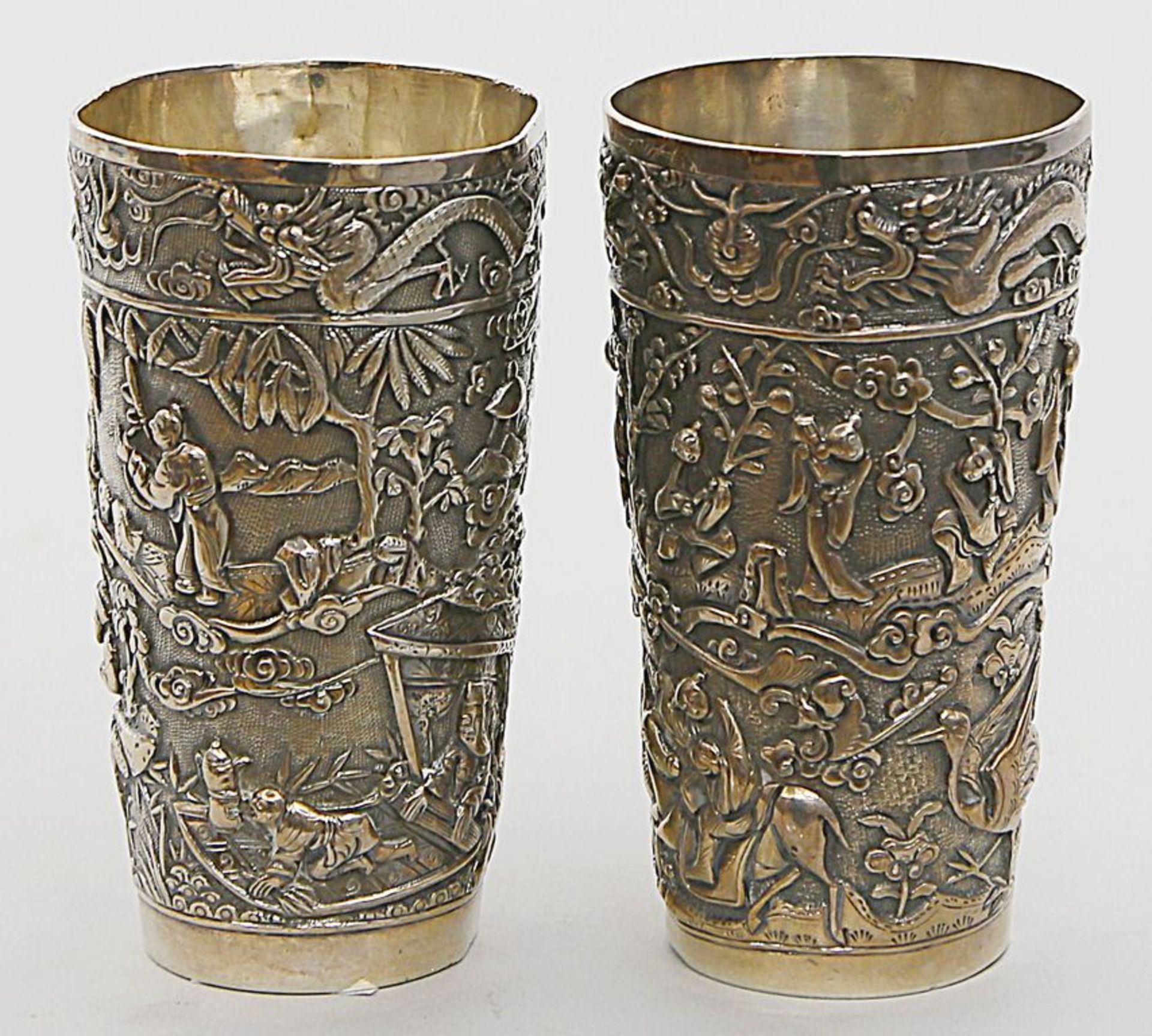 Paar Becher. Silber, 548 g. Konische Wandung, umlaufend mit reichem Reliefdekor von Landschaften mit