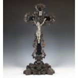 Zilveren corpus aan gezwart houten kruis