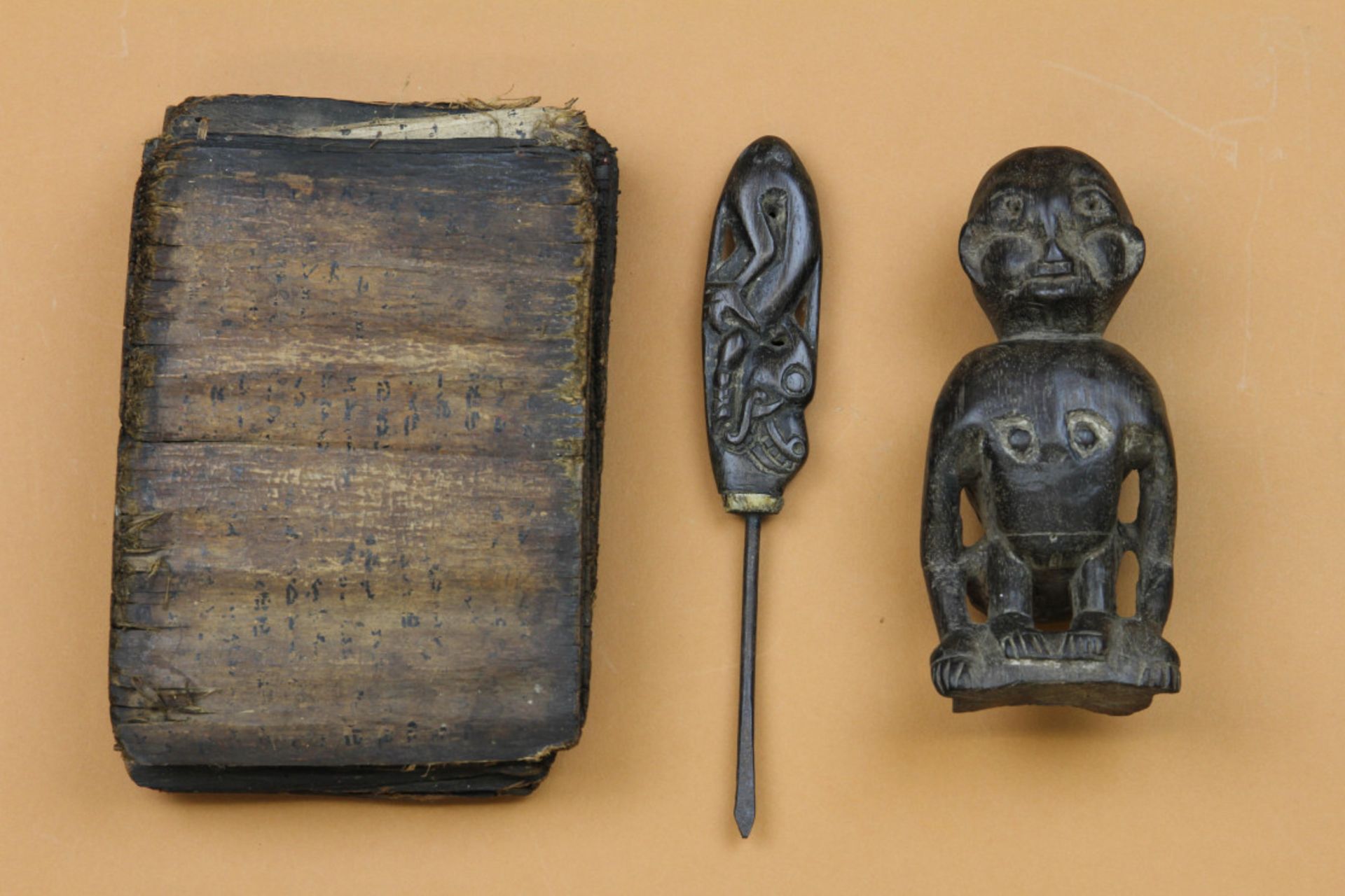 Dayak, braid prong and a carved wooden animal figure and Batak, a shaman book.