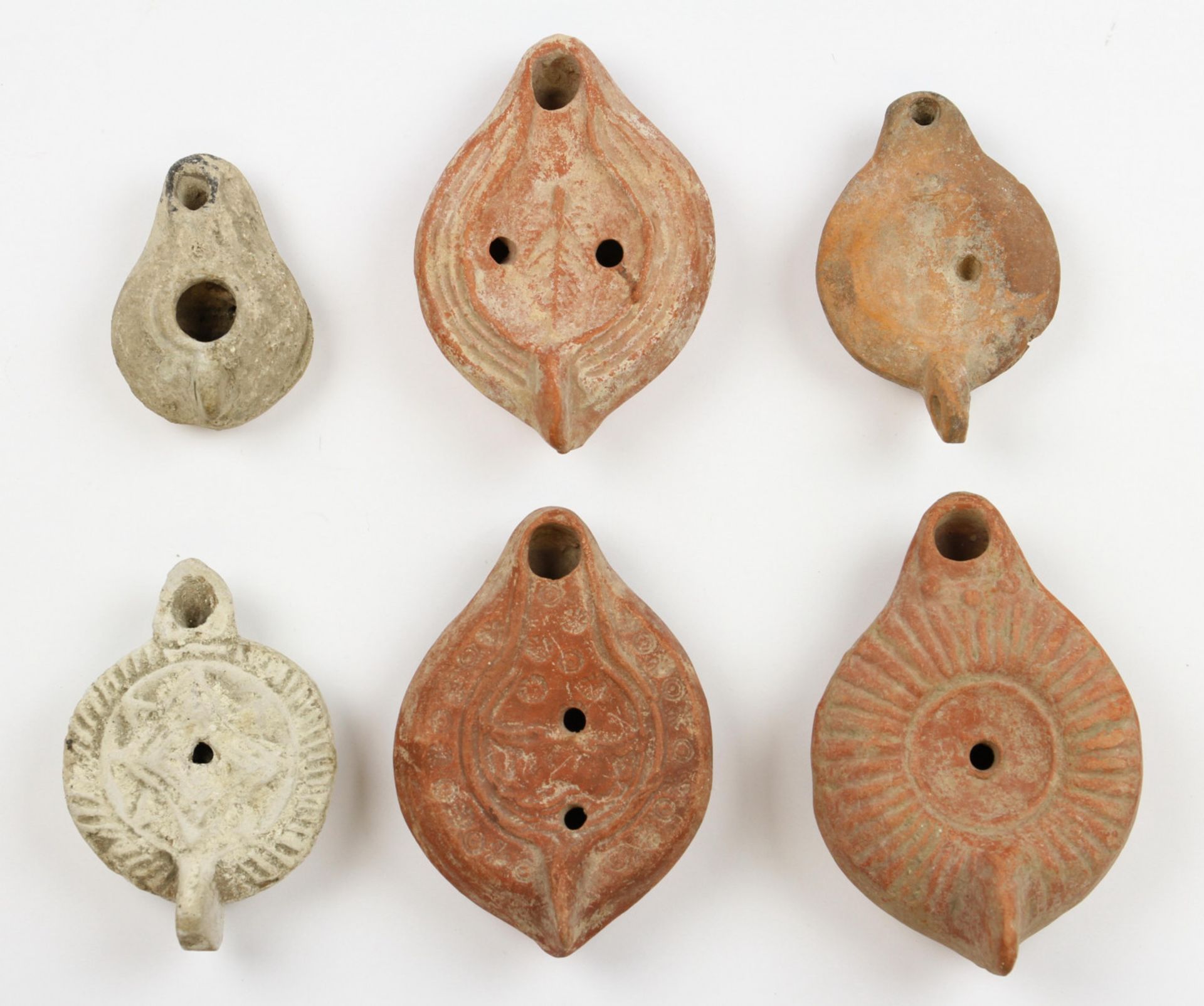 Collection of Roman oil lamps; four terracotta with decorations in