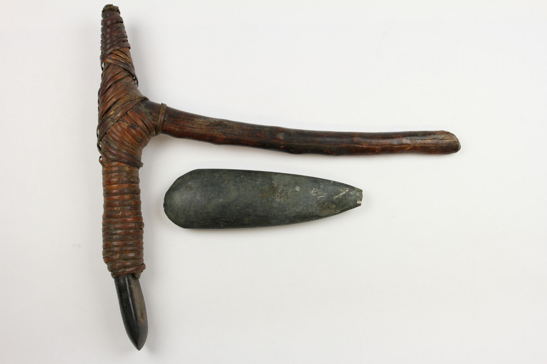 Papua, an axe with wooden and pyrochraphed handle and a wooden adz,