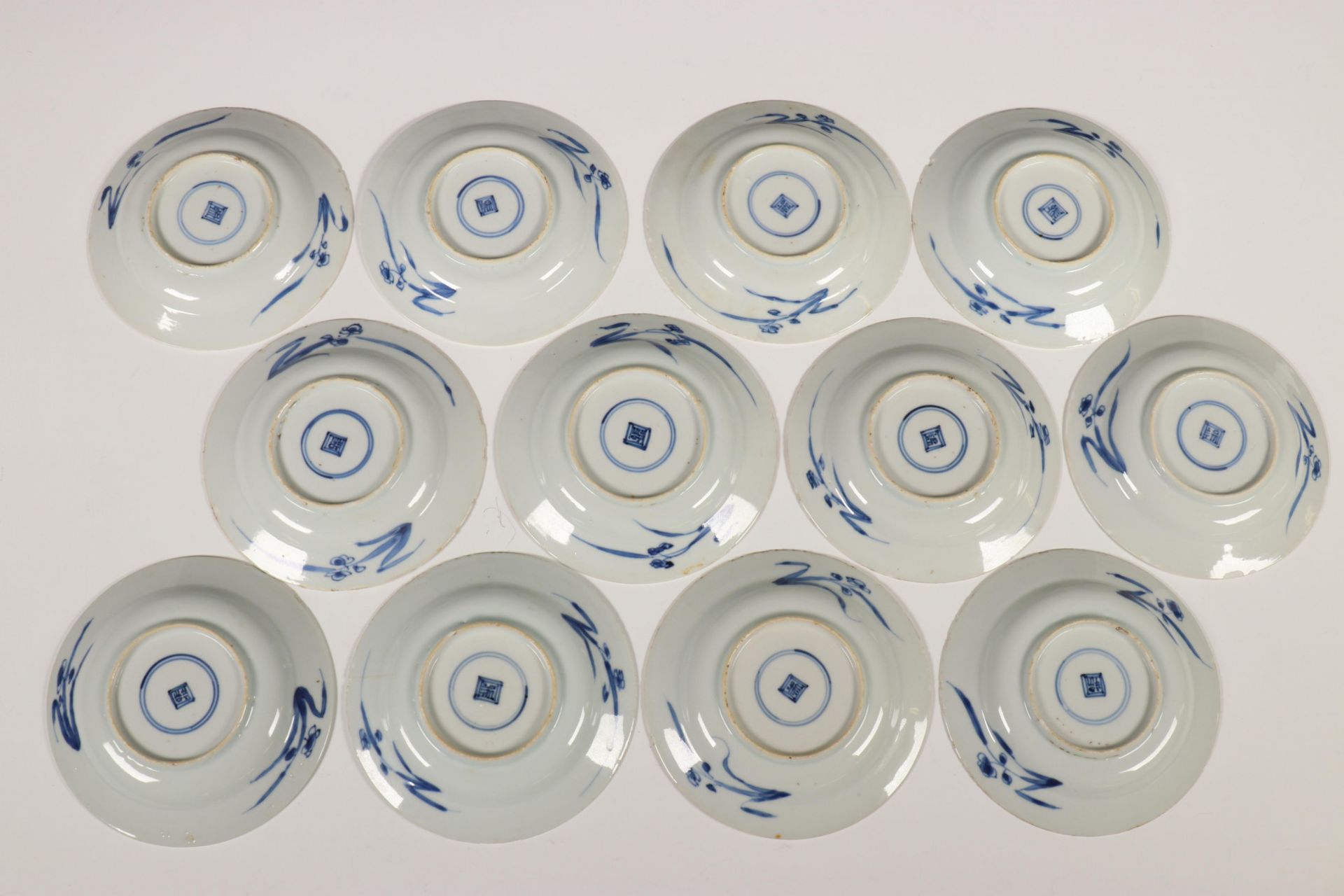 China, een set van twaalf blauw-wit porseleinen schoteltjes, Kangxi, - Image 8 of 16