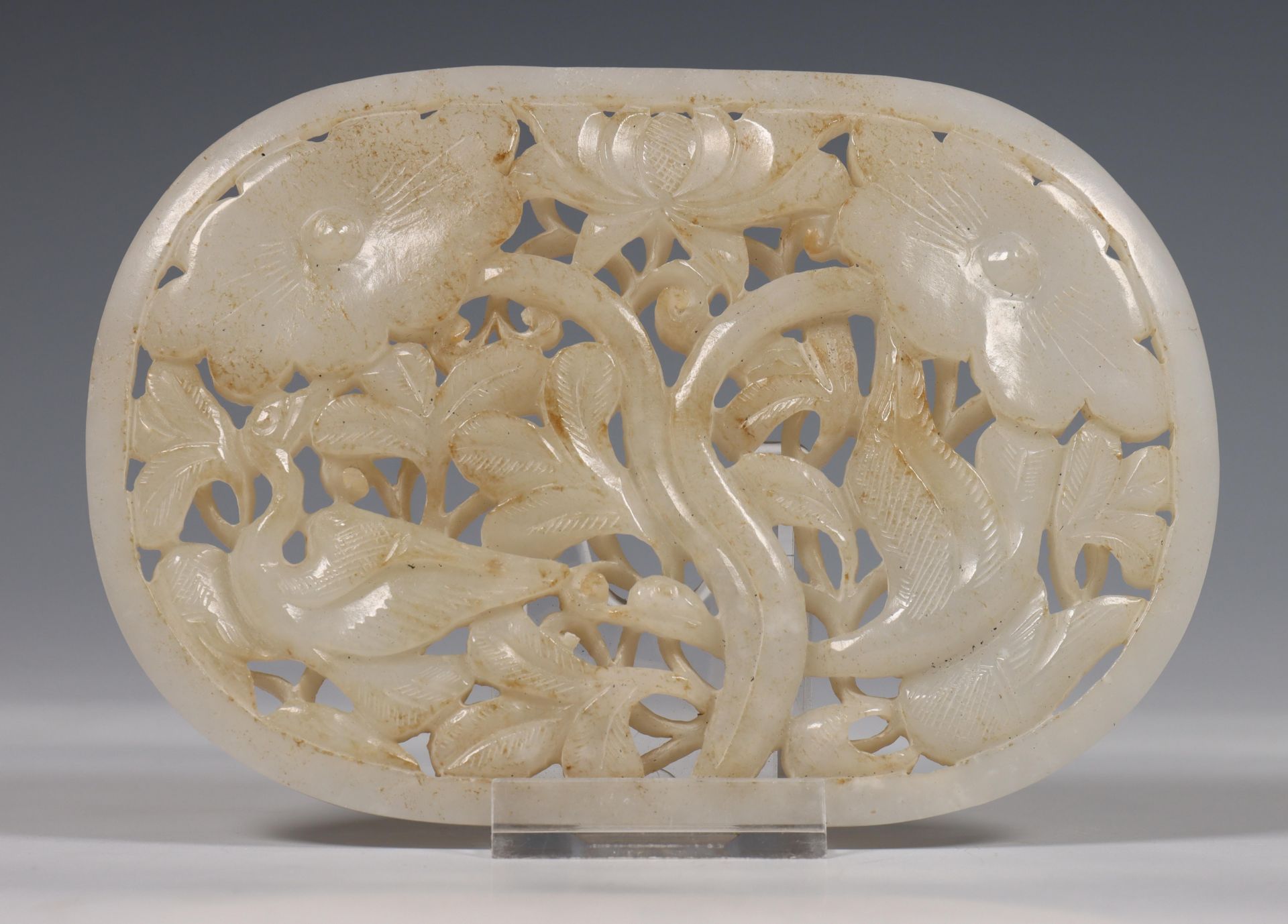 China, oval jade plaque, 19th-20th century, openworked and carved with geese among flowers, the